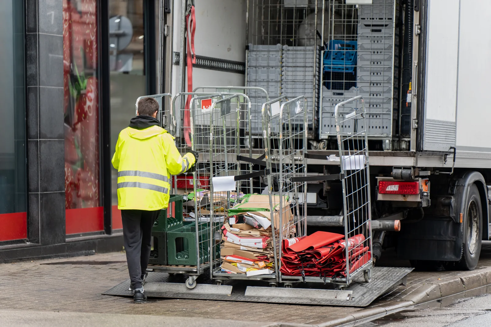Worker handling roll cages at a loading dock